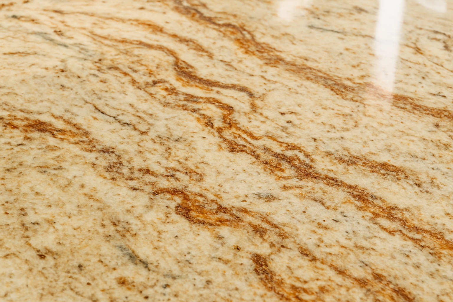 Close-up view of butter rum granite counter highlighting its creamy base color and intricate swirls and speckles.